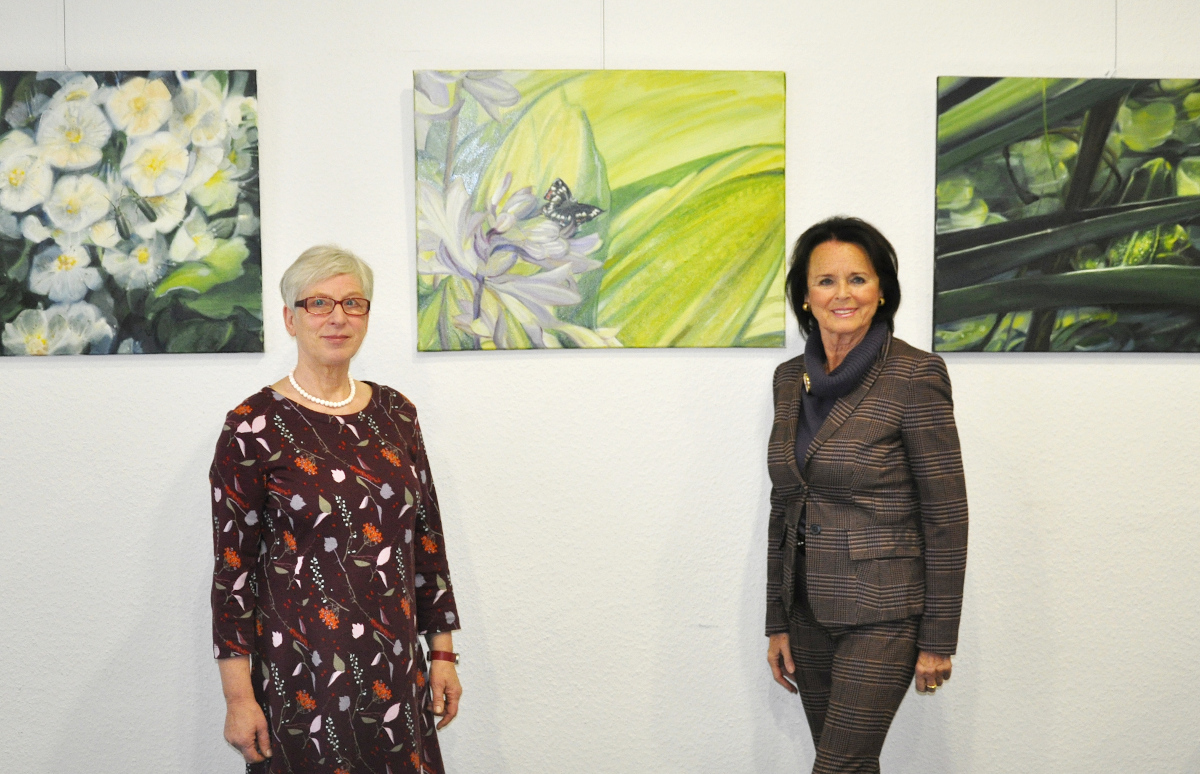 Katrin Boidol und Elke Hardieck (v.l.) im Konrad-Adenauer-Haus vor der neuen Bilderserie mit Gartenmotiven, die in diesem Jahr entstanden ist.